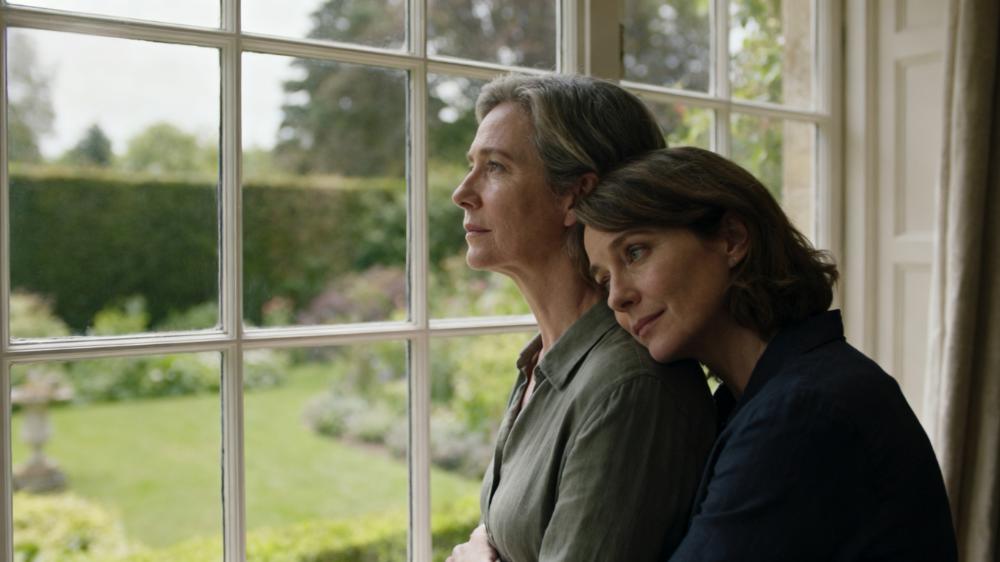 Two partners sharing a quiet, intimate moment by a window, a perfect illustration of what is emotional intimacy.