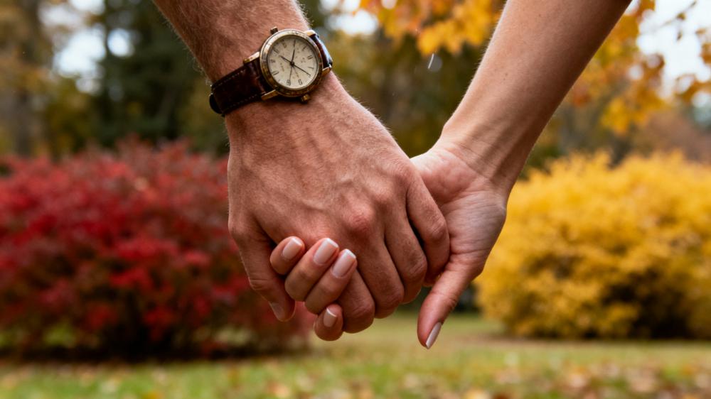 A close-up of a couple's hands intertwined while walking, demonstrating physical intimacy exercises beyond sex and how simple touches build connection.