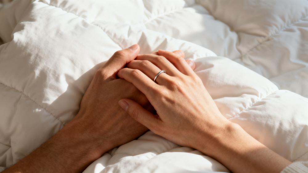 A close-up of a couple's hands intertwined, a simple but powerful part of a morning routine for couples.